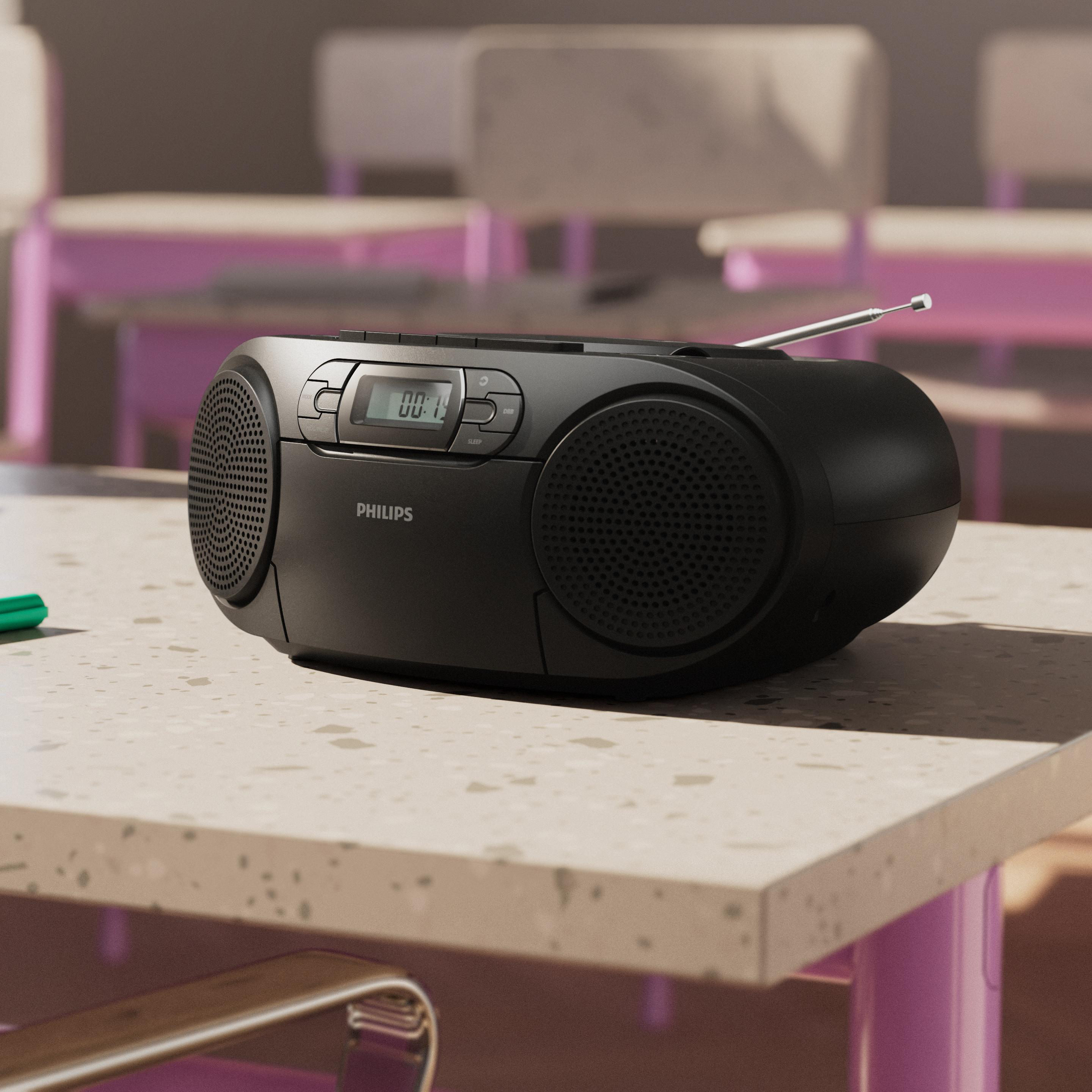 Ein schwarzer Philips Ghettoblaster steht auf einem gesprenkelten Tisch in einem Klassenzimmer.