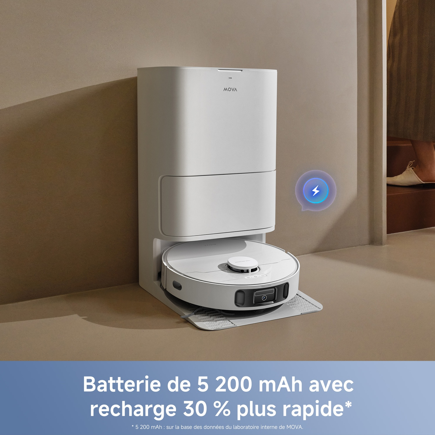 Une station d'aspirateur robot Mova blanche contre un mur beige, avec un robot en charge.