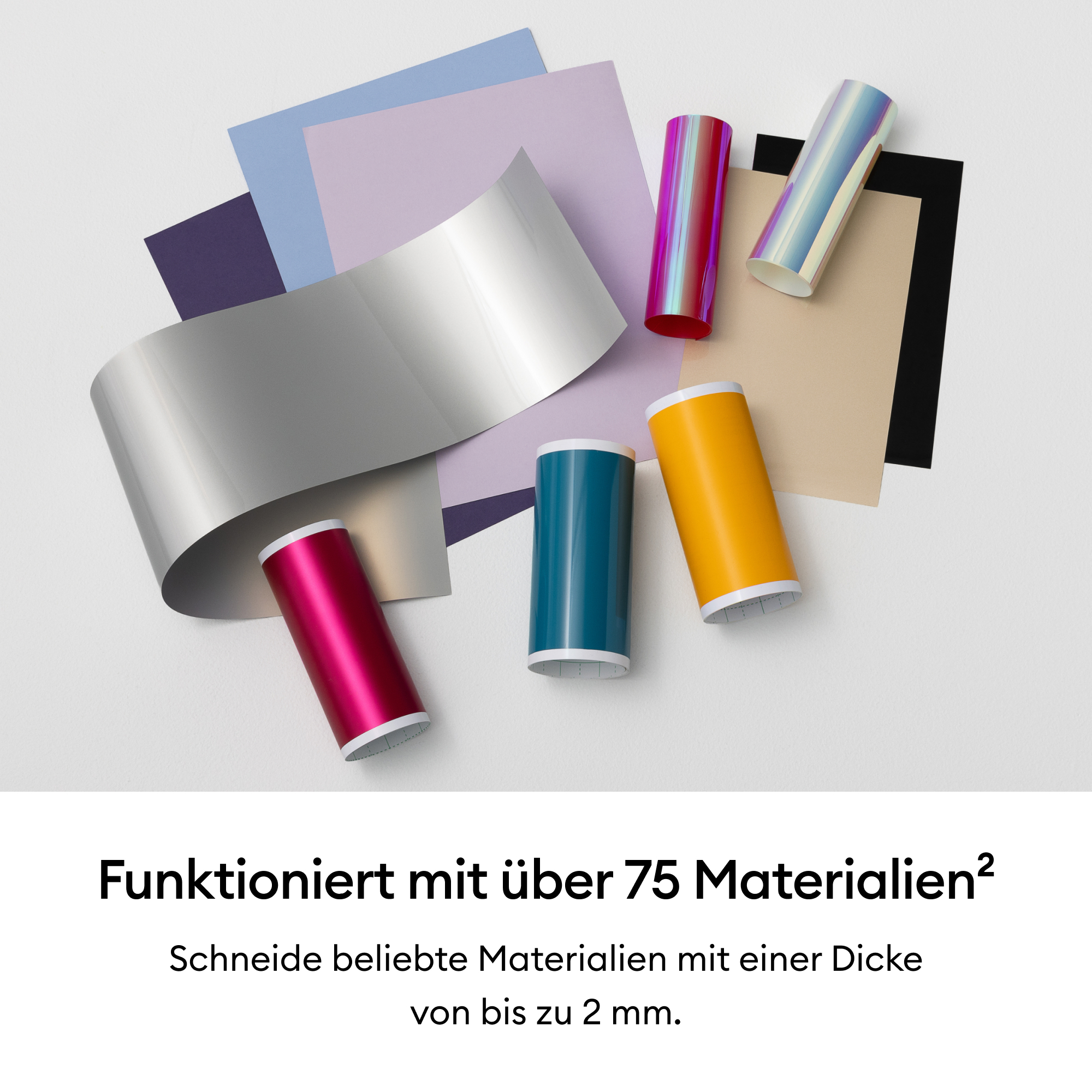 Bunte Bastelmaterialien und Vinylrollen auf weißer Oberfläche angeordnet.