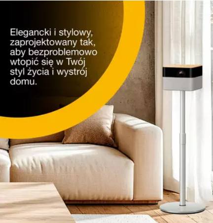 Biała lampa stoi w nowoczesnym salonie obok jasnej kanapy.