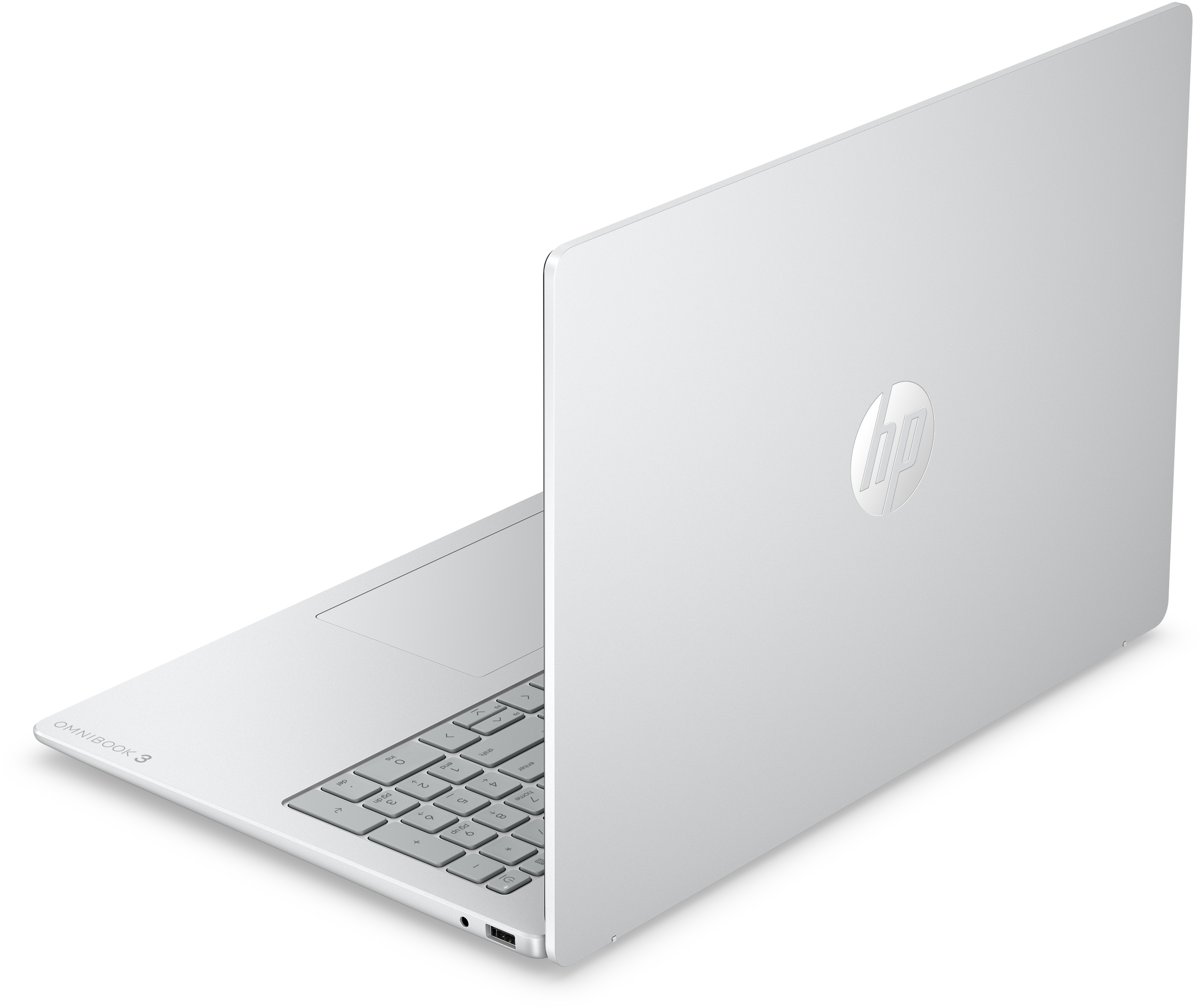 Egy ezüst színű HP Omnibook 3 laptop fehér felületen áll, látszik a billentyűzet egy része és a logó.