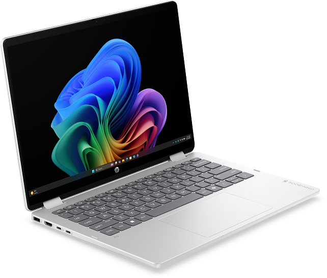 Egy ezüst színű laptop fekete billentyűzettel és színes absztrakt háttérképpel a képernyőn.
