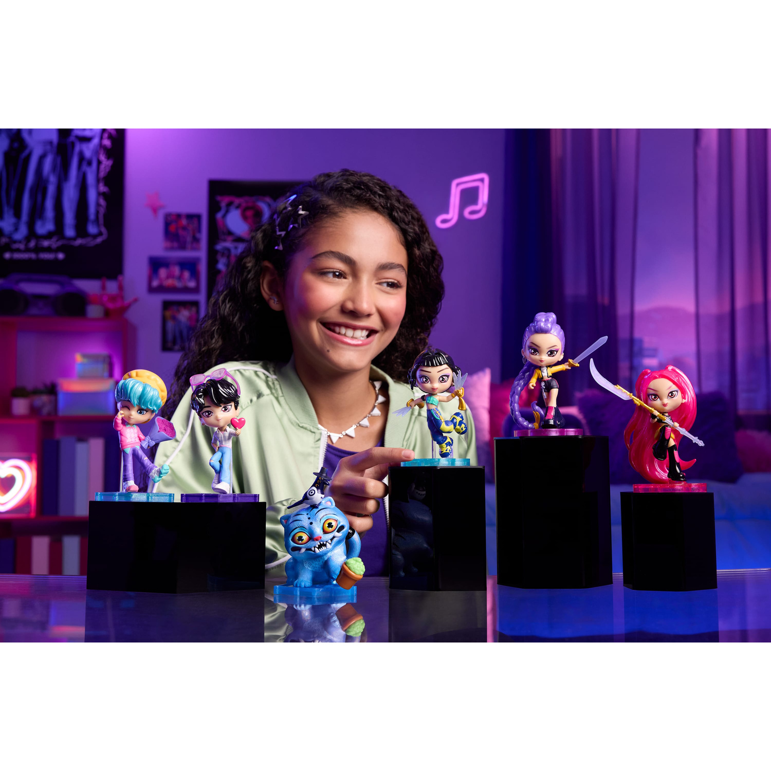 Una ragazza sorridente guarda piccole action figure su piedistalli neri in una stanza con illuminazione viola.