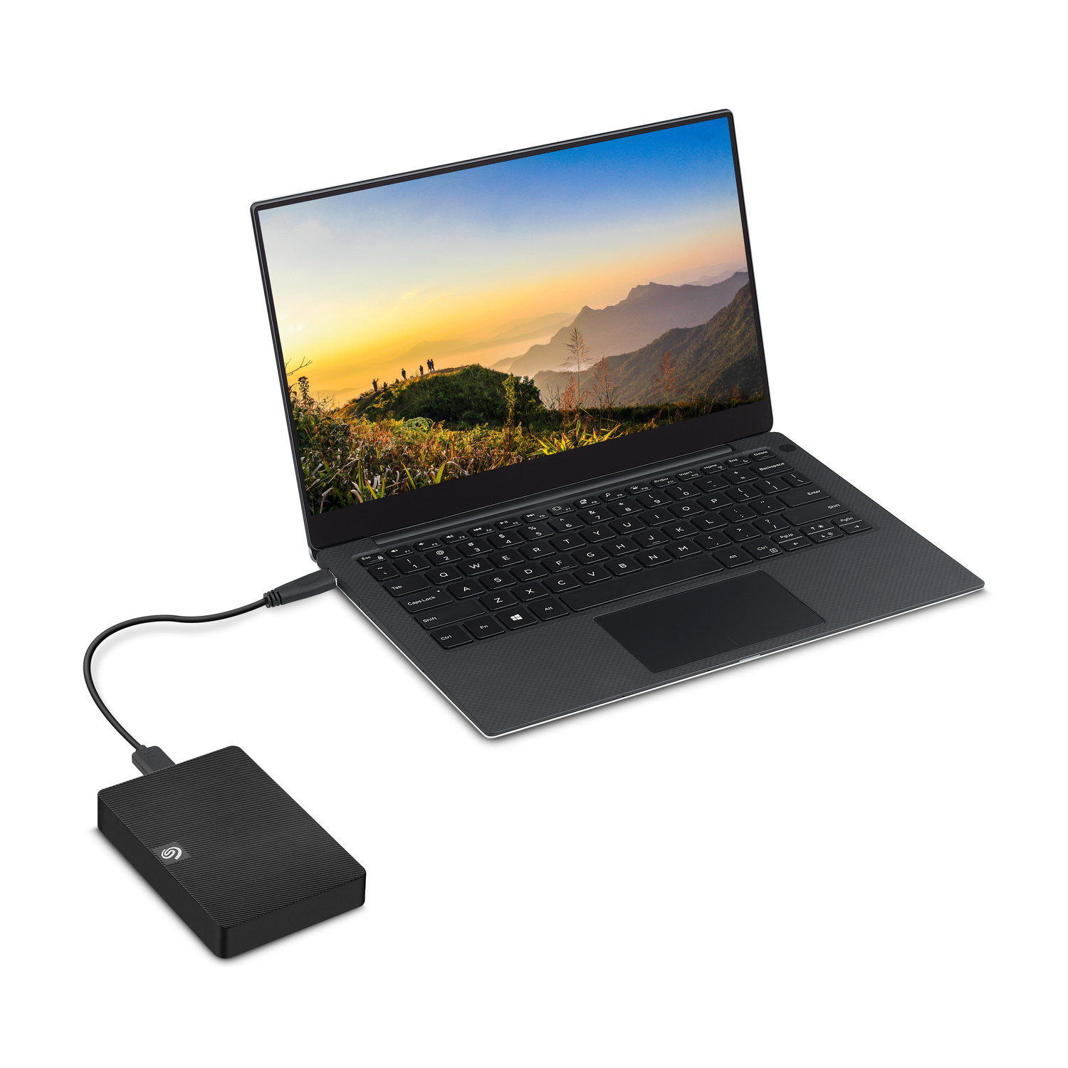 Un computer portatile nero con uno sfondo di montagna è collegato a un disco rigido esterno.