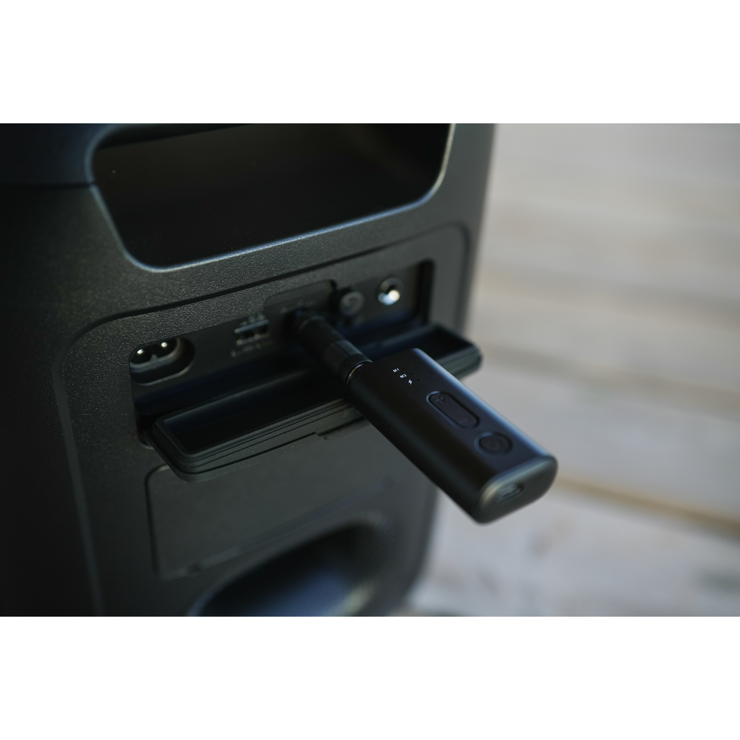 Un dispositivo USB nero è collegato al pannello posteriore di un grande dispositivo.