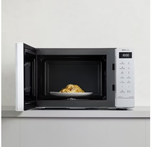 Otwarta biała kuchenka mikrofalowa na blacie, w środku talerz jedzenia.