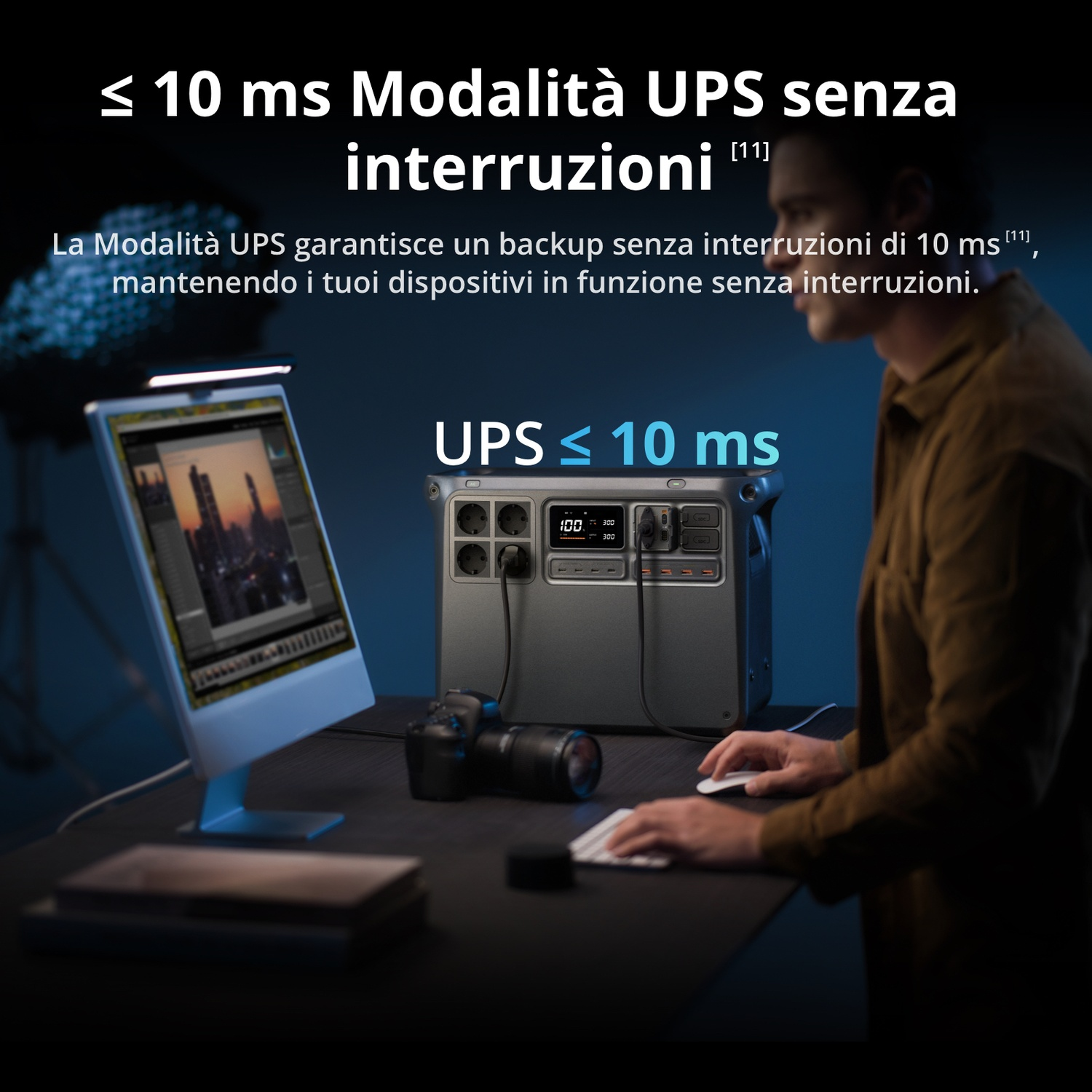 Un uomo siede a una scrivania con un computer e una centrale elettrica con modalità UPS.