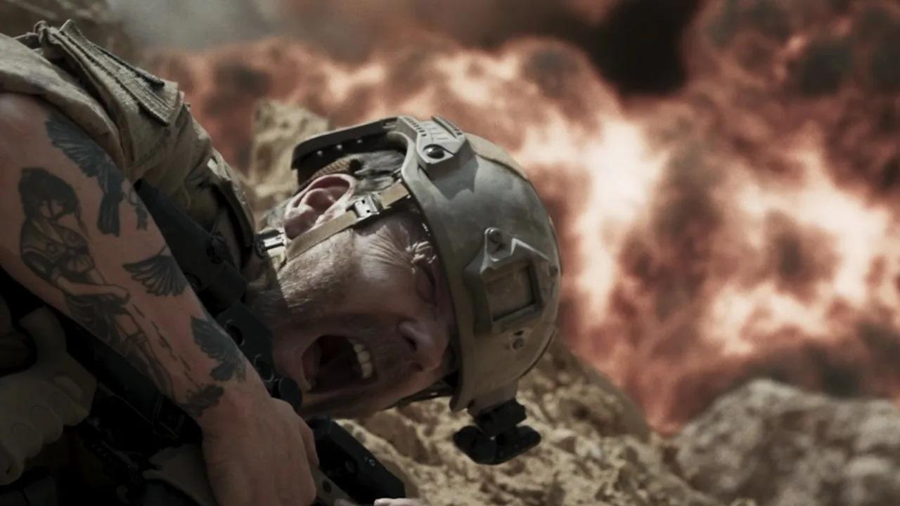 Ein Soldat mit Helm schreit vor Schmerz, während hinter ihm eine Explosion zu sehen ist.