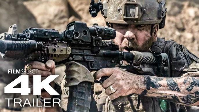 Ein Soldat mit Helm und Tattoos hält ein Sturmgewehr in einer kargen Umgebung.