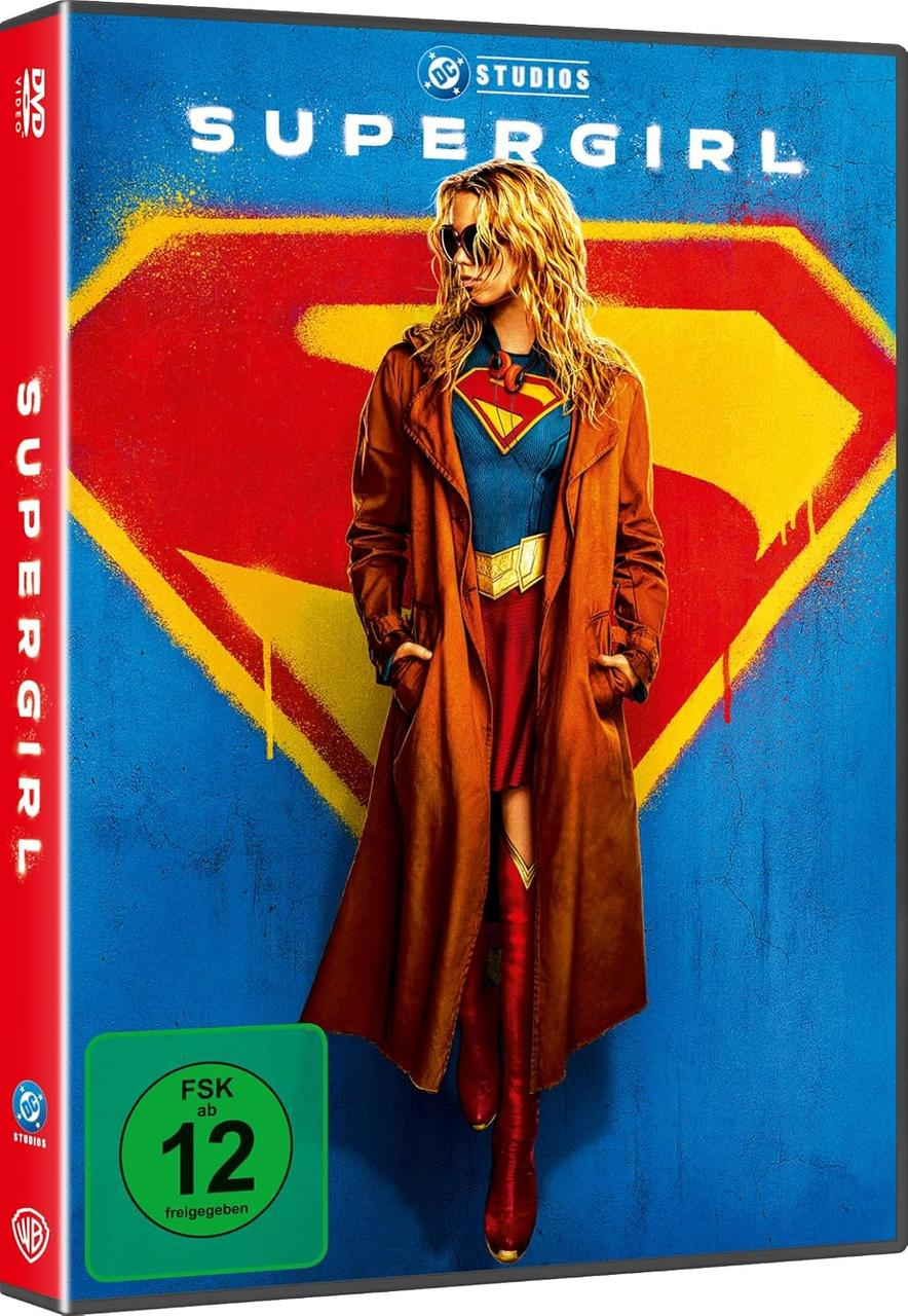 Supergirl-DVD-Hülle mit einer blonden Frau im Trenchcoat über einem Supergirl-Kostüm vor blau-gelbem Hintergrund.