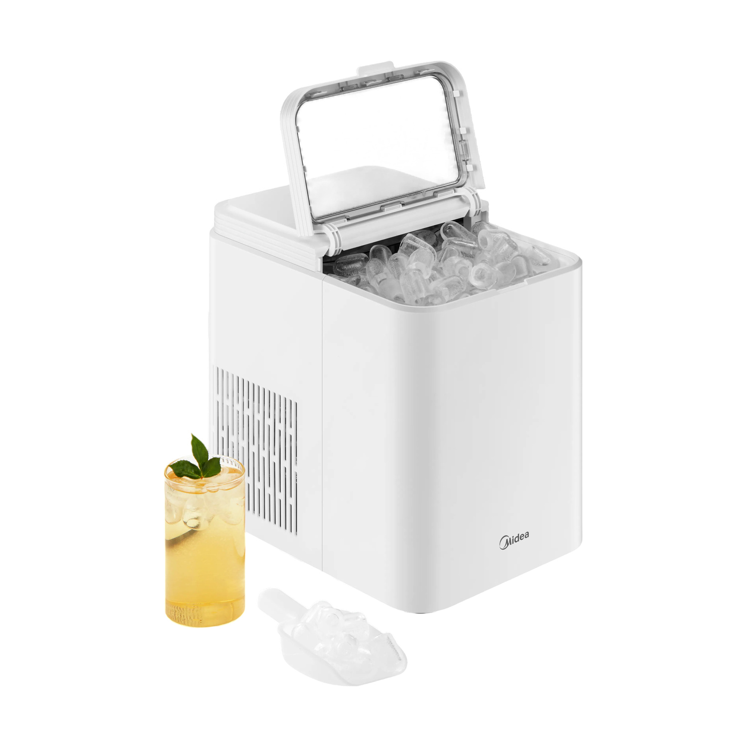 Una macchina per ghiaccio bianca con coperchio aperto, piena di cubetti, accanto a un bicchiere di succo.