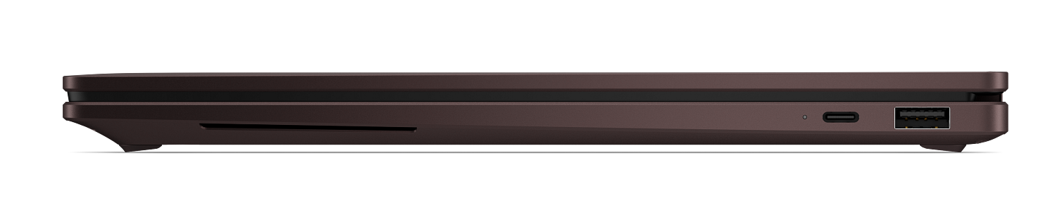 Widok z boku zamkniętego ciemnego laptopa z portami USB na czarnym tle.
