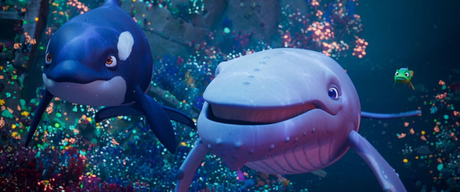 Ein animierter Orca und ein weißer Wal schwimmen vor einem bunten Korallenriff.