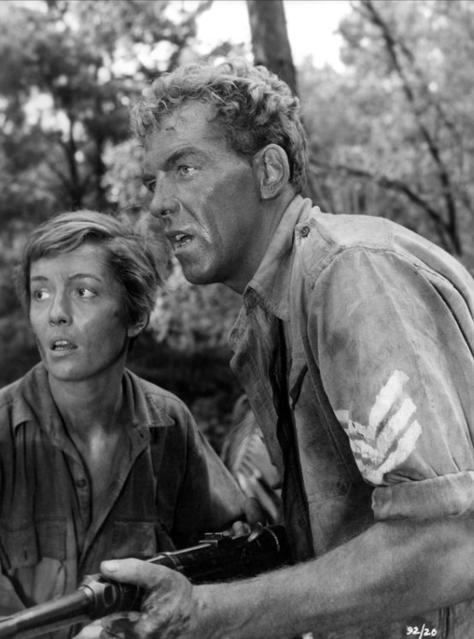 Schwarz-Weiß-Foto von Mann und Frau mit Gewehr im Wald.