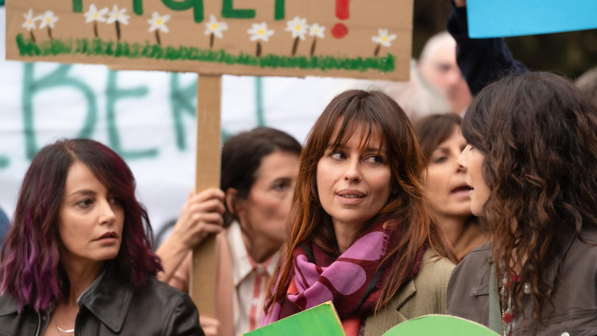 Frauen bei einer Demonstration halten Pappschilder hoch.