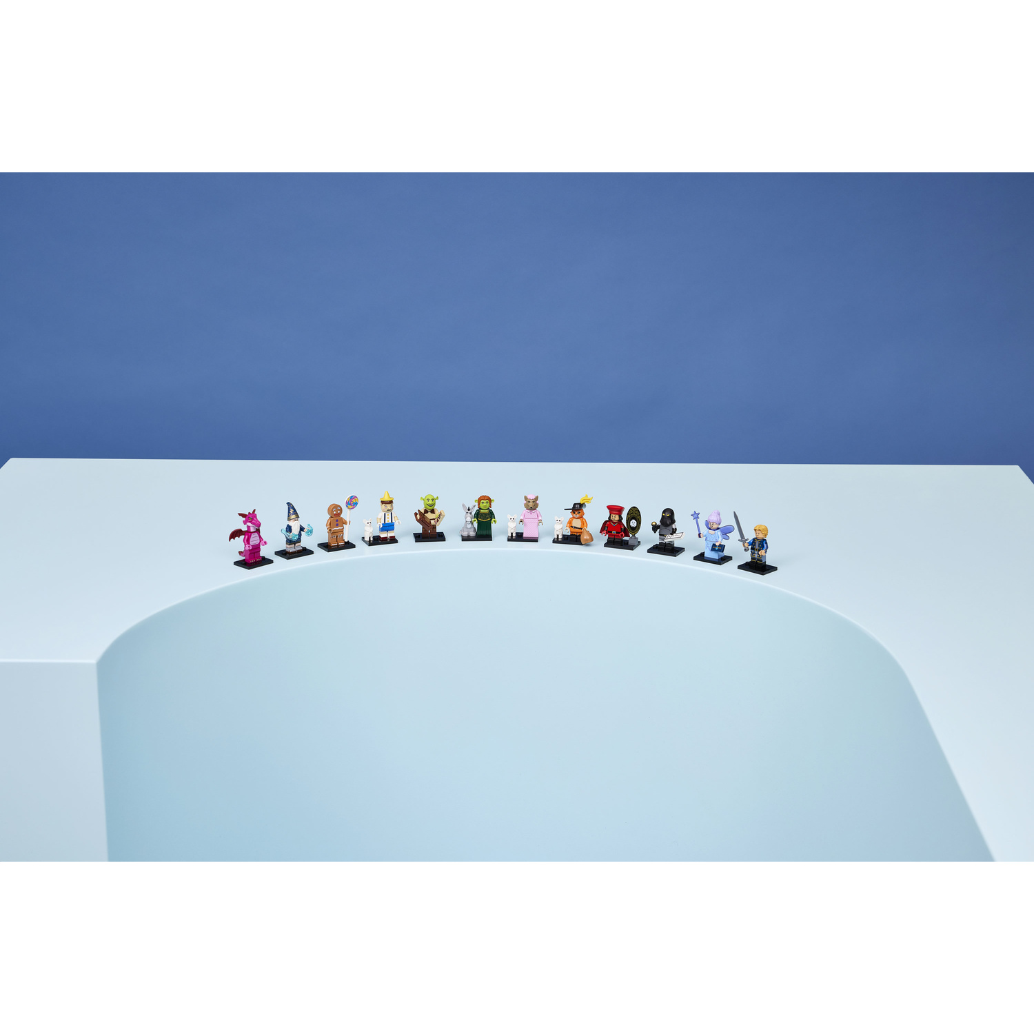 Una fila di minifigure Lego si trova su una superficie azzurra su sfondo blu.