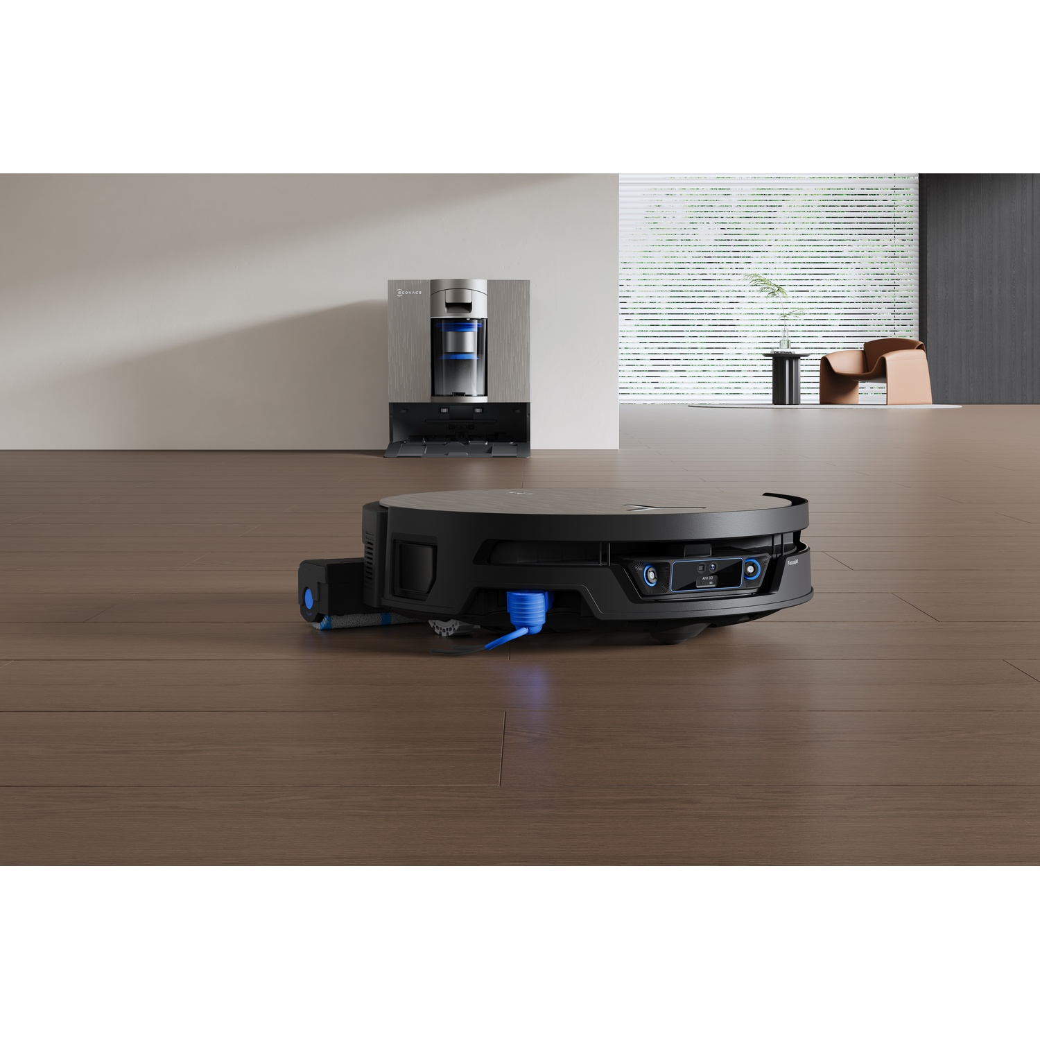 Un robot aspirapolvere nero su un pavimento in legno davanti a una stazione di ricarica in una stanza minimalista.