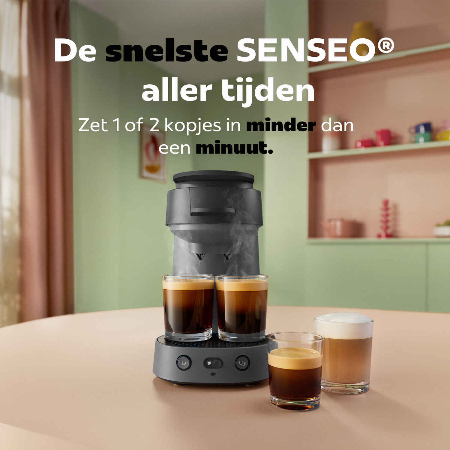 Een grijze Senseo koffiemachine op tafel zet twee kopjes verse koffie in een lichtgroene keuken.