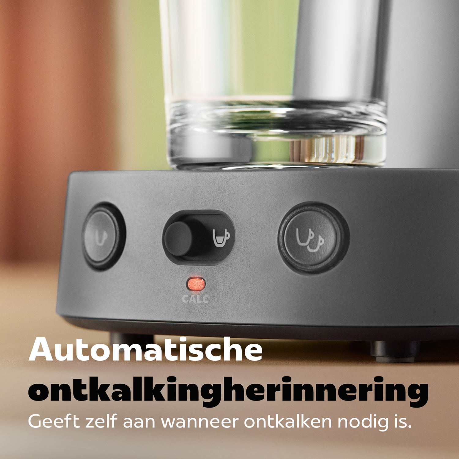 Grijze koffiemachinebasis met knoppen en een rode ontkalkingsindicator.