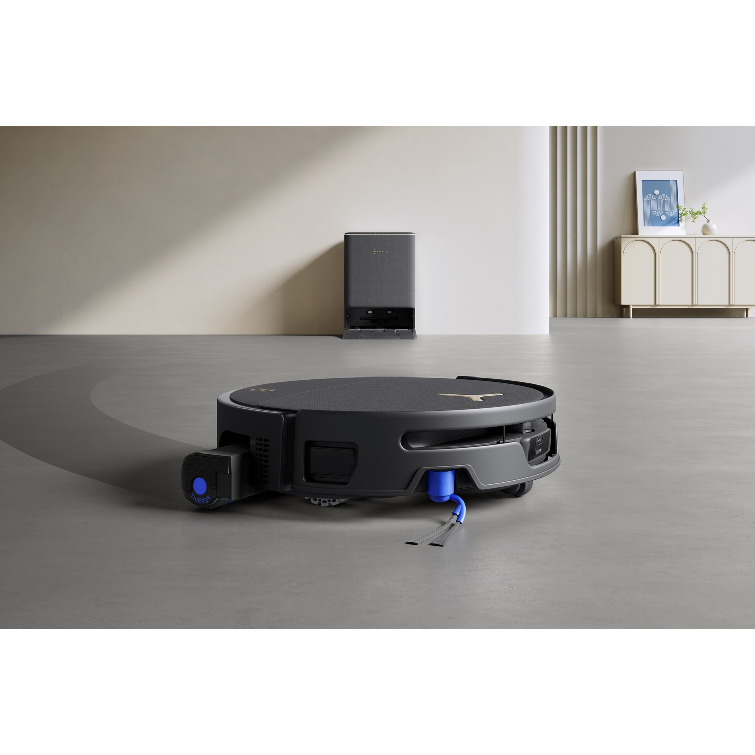 Un robot aspirapolvere nero si trova su un pavimento grigio davanti a una parete minimalista con stazione di ricarica.