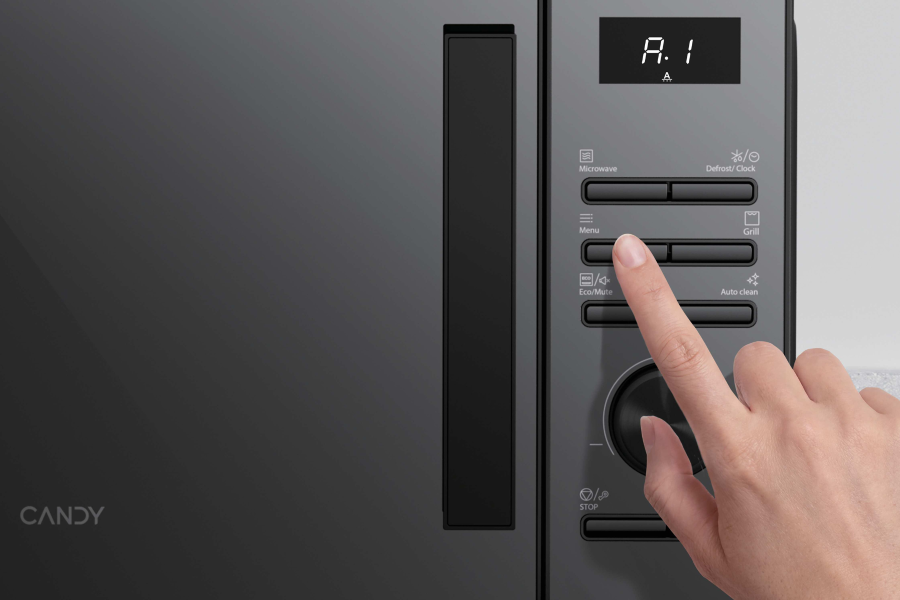 Una mano presionando un botón en el panel de control de un microondas gris.