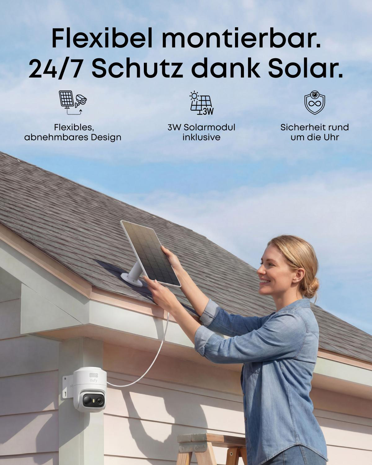Eine Frau montiert ein Solarmodul am Hausdach mit einer Überwachungskamera.