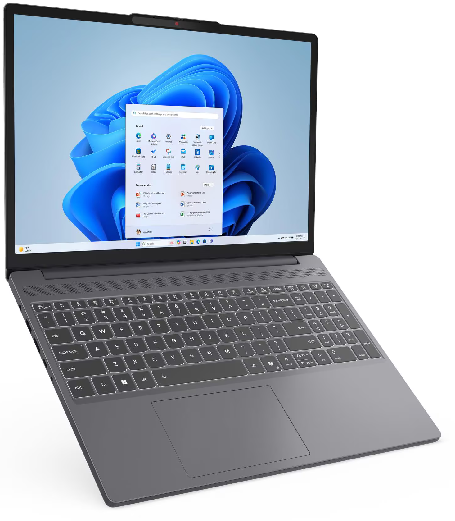 Egy szürke laptop nyitott képernyővel mutatja a Windows 11 Start menüt és kék hullám hátteret.