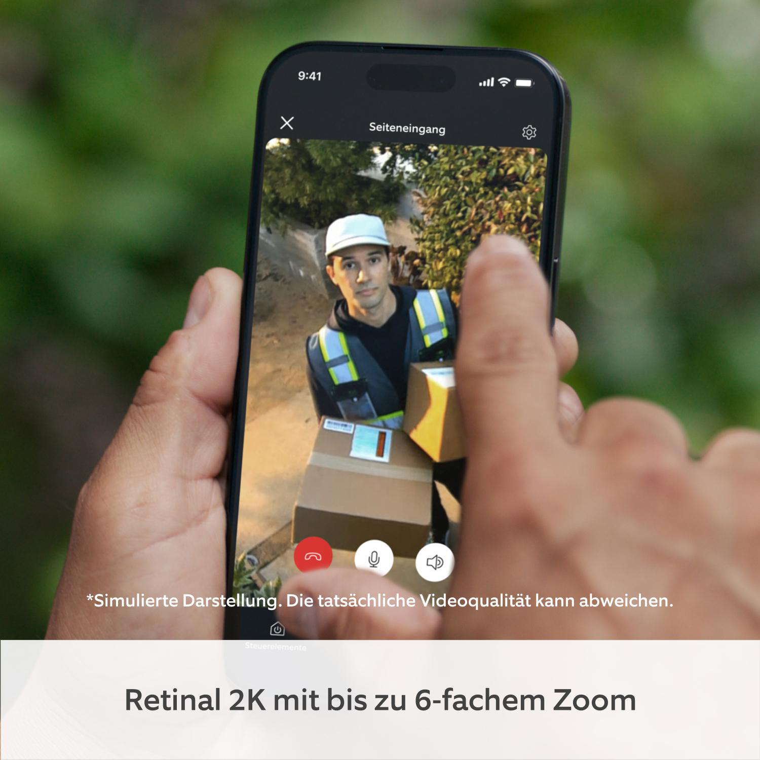Smartphone-Bildschirm zeigt einen Lieferanten mit Paketen vor einer Hecke.