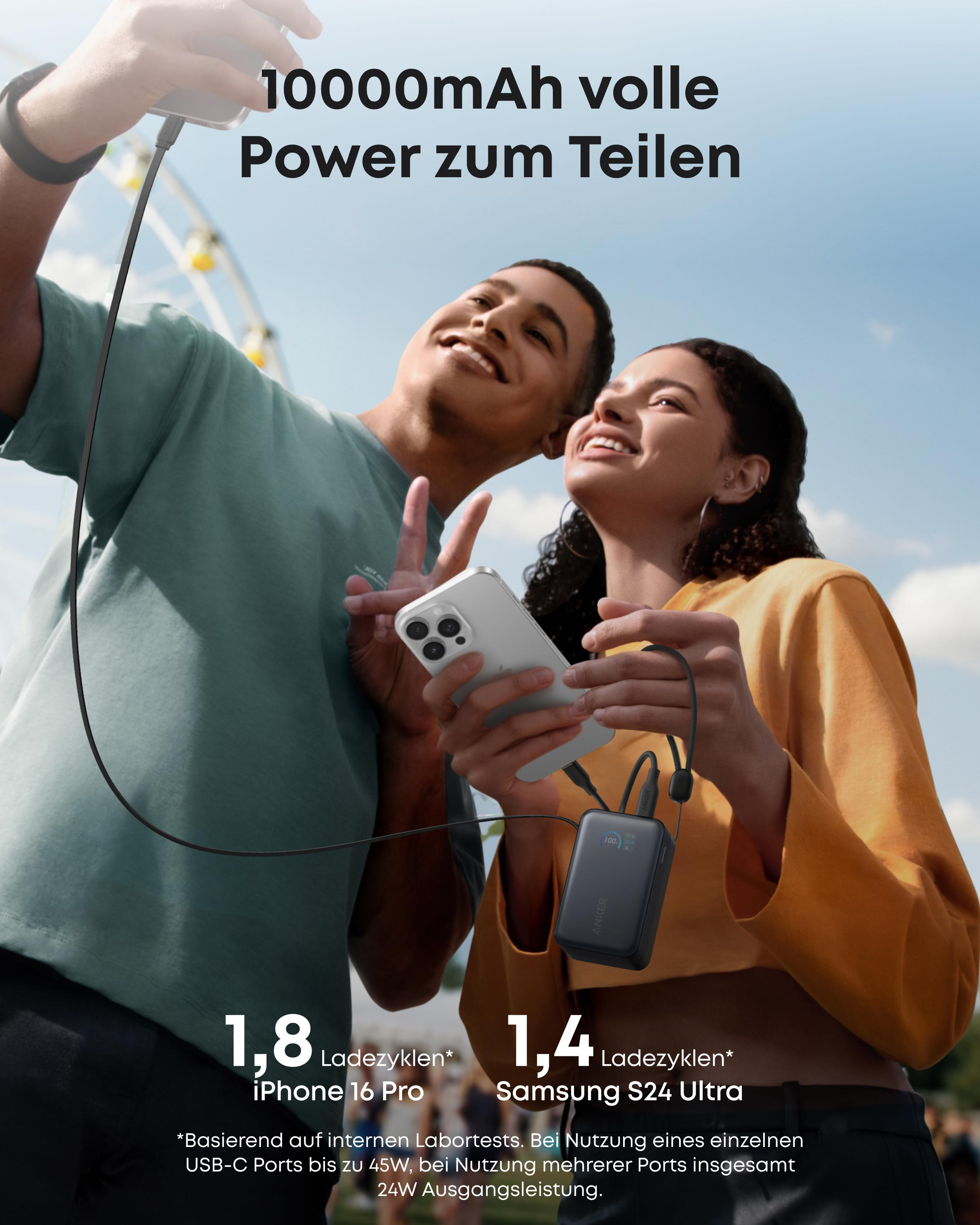 Zwei junge Leute lächeln und nutzen eine Powerbank zum Laden ihrer Smartphones im Freien.