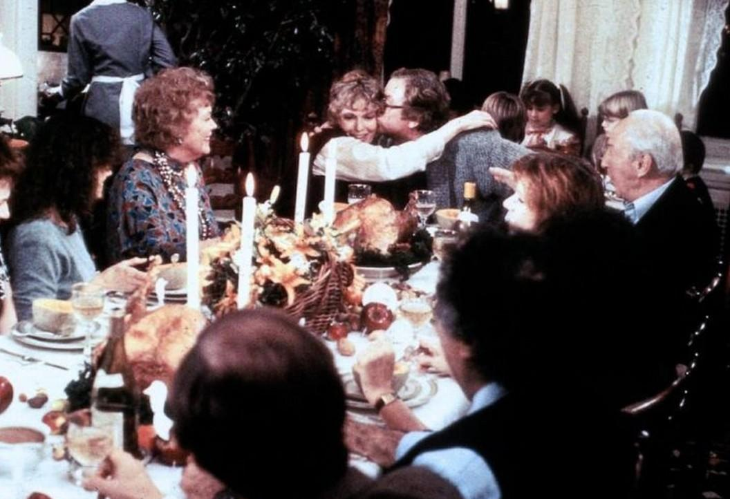 Eine Familie versammelt sich zum festlichen Abendessen an einem gedeckten Tisch mit Kerzen.