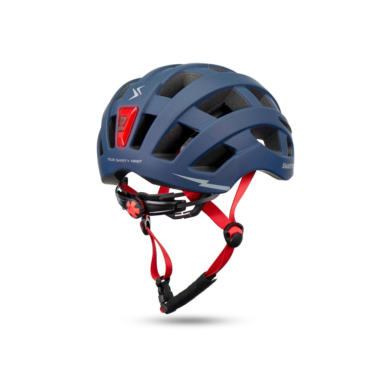 Casco de bicicleta azul con correas rojas y luz trasera integrada sobre fondo blanco.