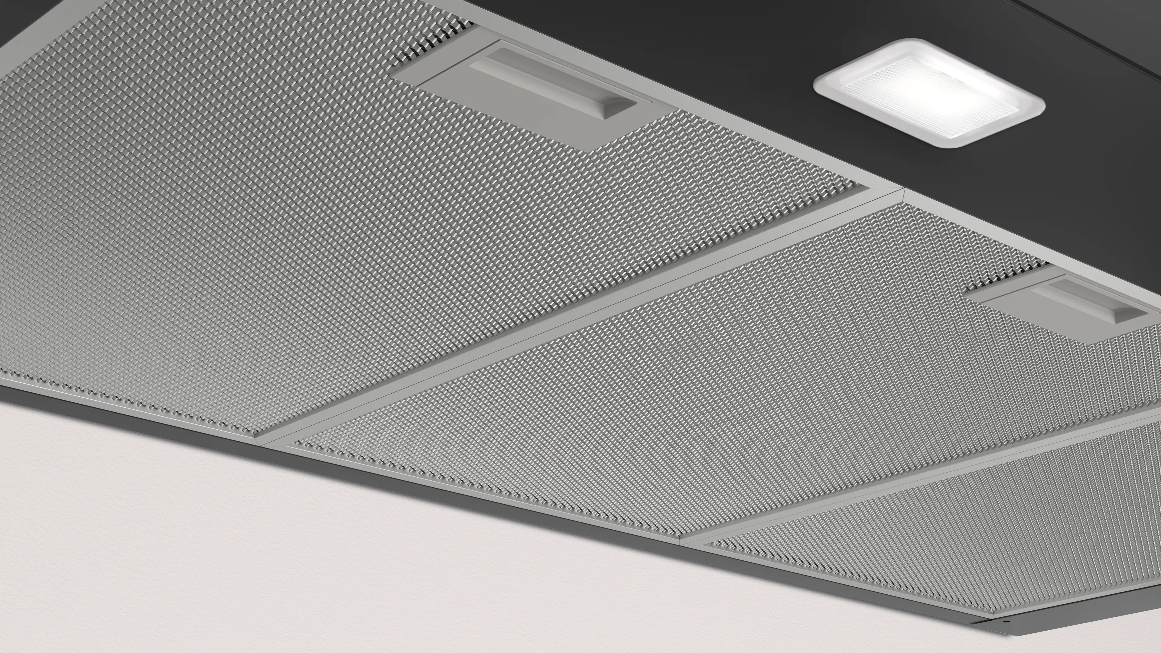 Vista inferior de una campana extractora con filtros metálicos y una luz LED.