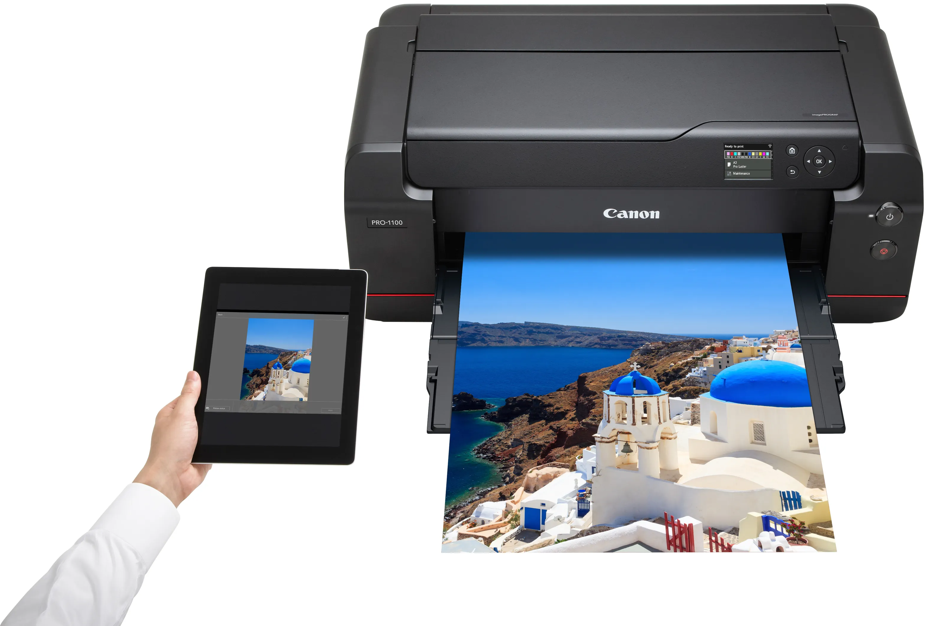 Una stampante stampa una foto di Santorini mentre un tablet viene tenuto accanto.