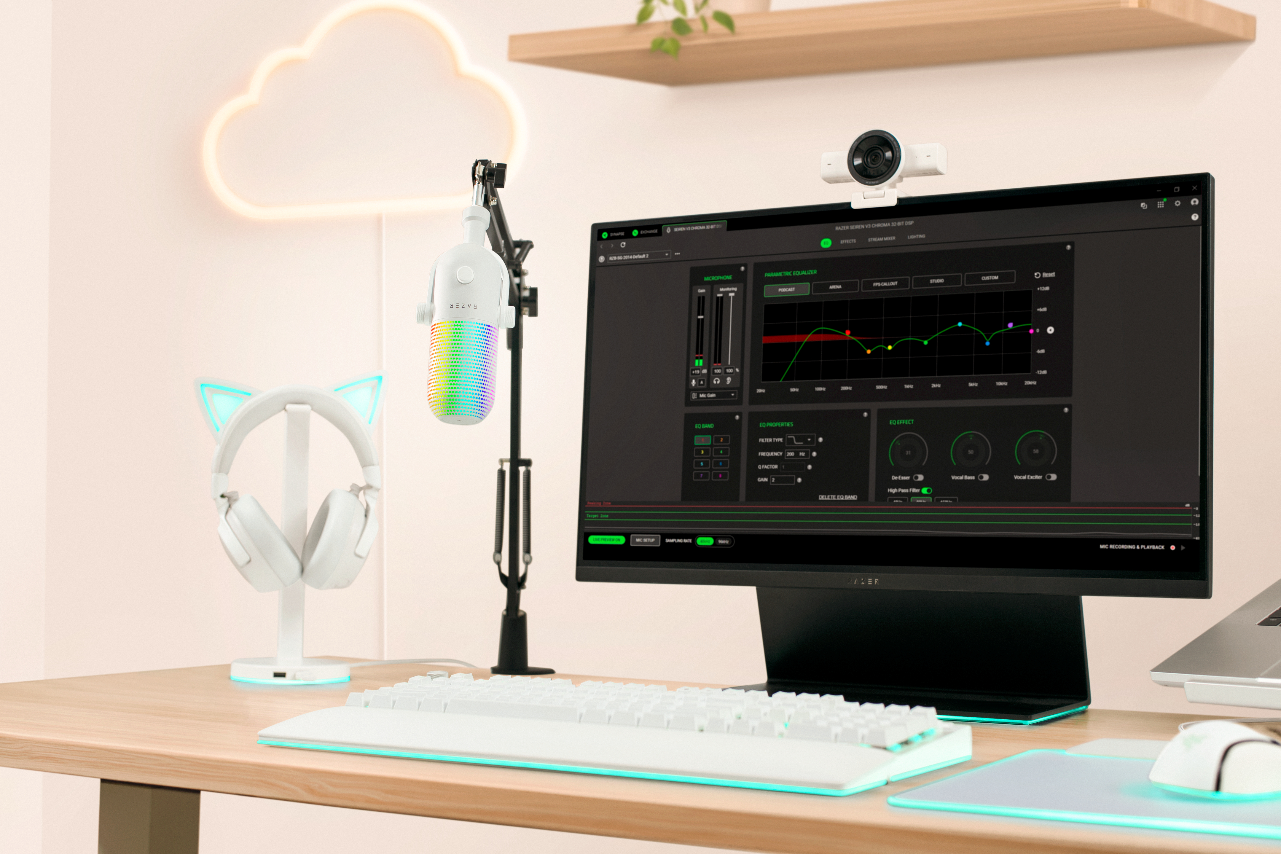 Gaming-Schreibtisch mit weißer Tastatur, Mikrofon, Headset und Monitor, der Equalizer-Software anzeigt.