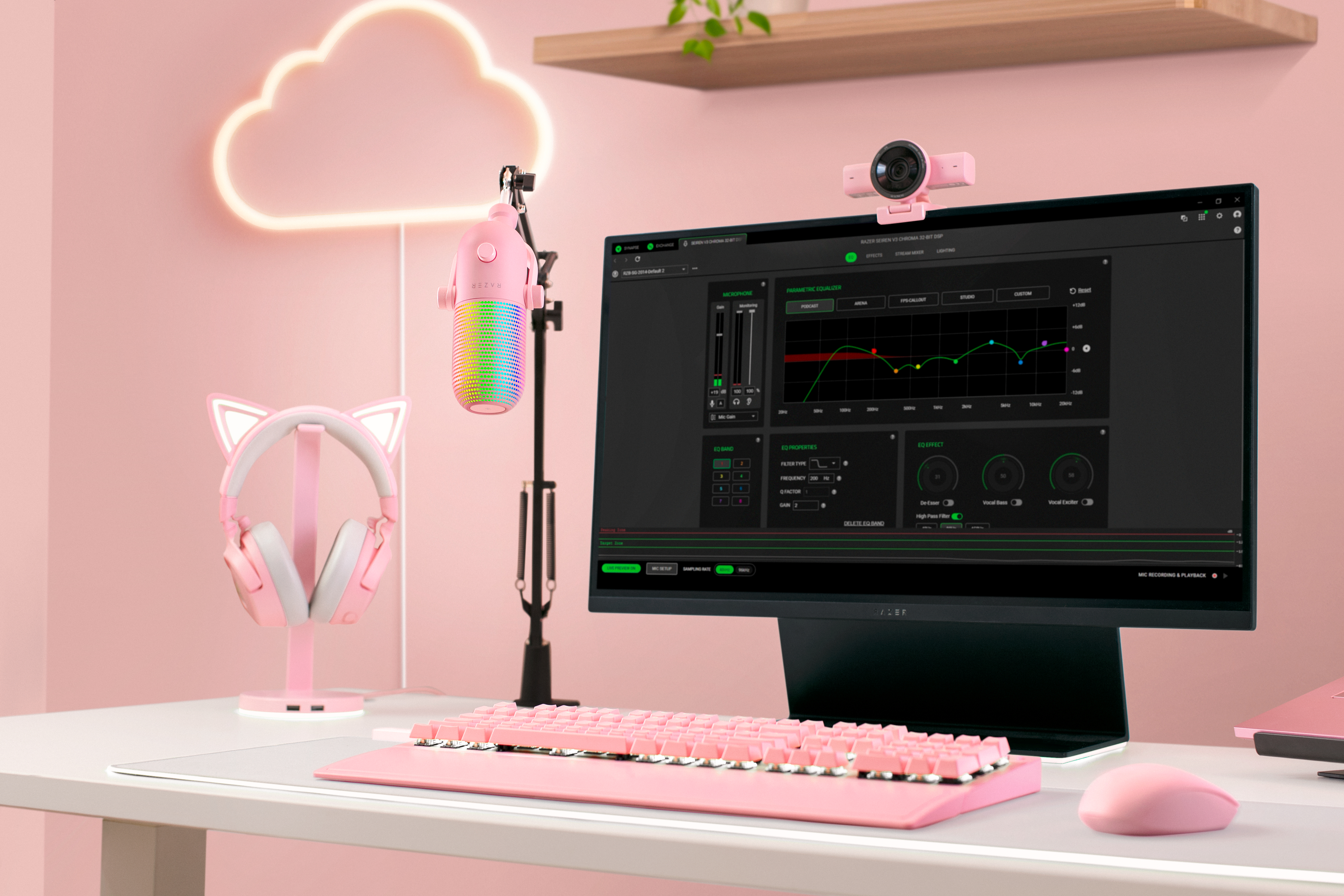 Ein pinker Gaming-Schreibtisch mit Monitor, Mikrofon, Tastatur, Maus und Katzenohren-Headset.