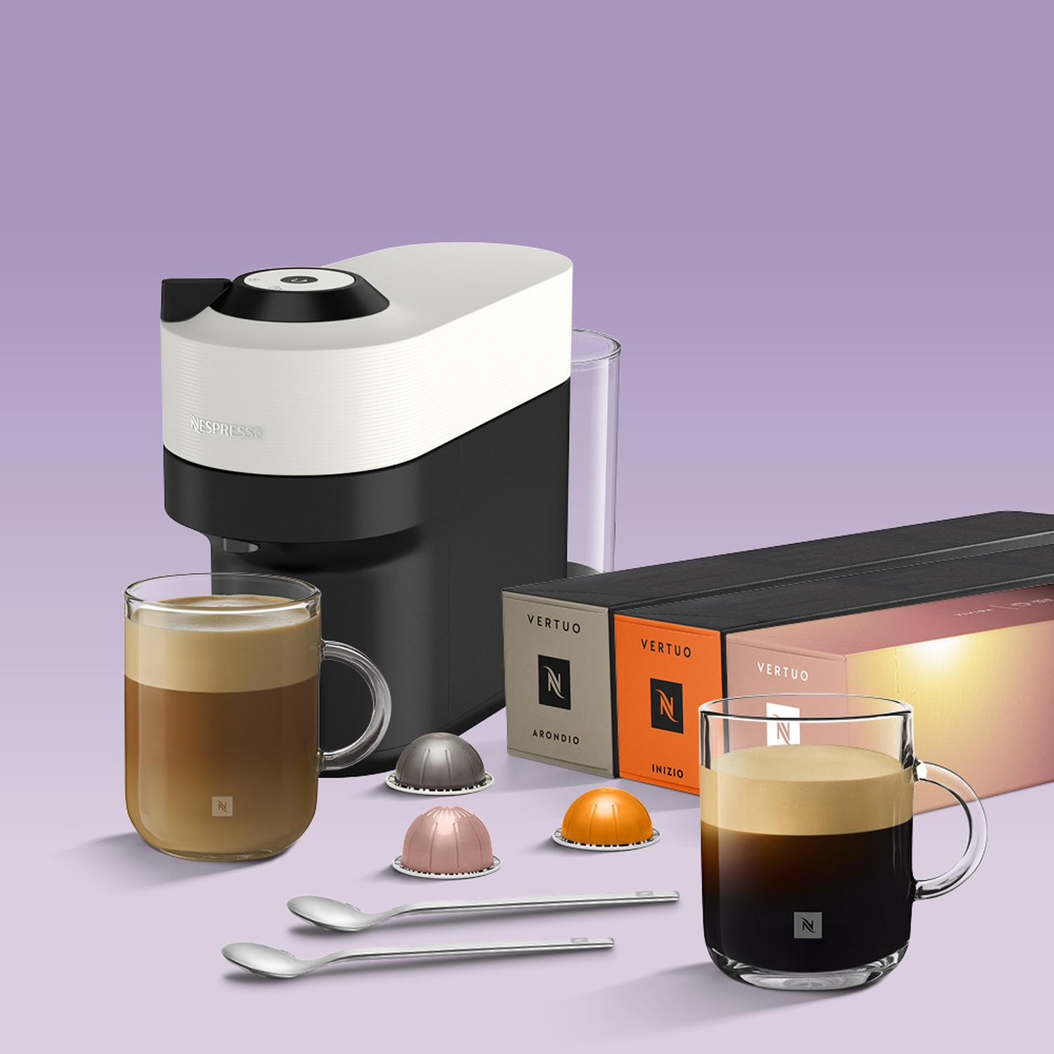 A black and white Nespresso coffee machine, coffee pods, two cups of coffee, and capsule boxes on a purple background.