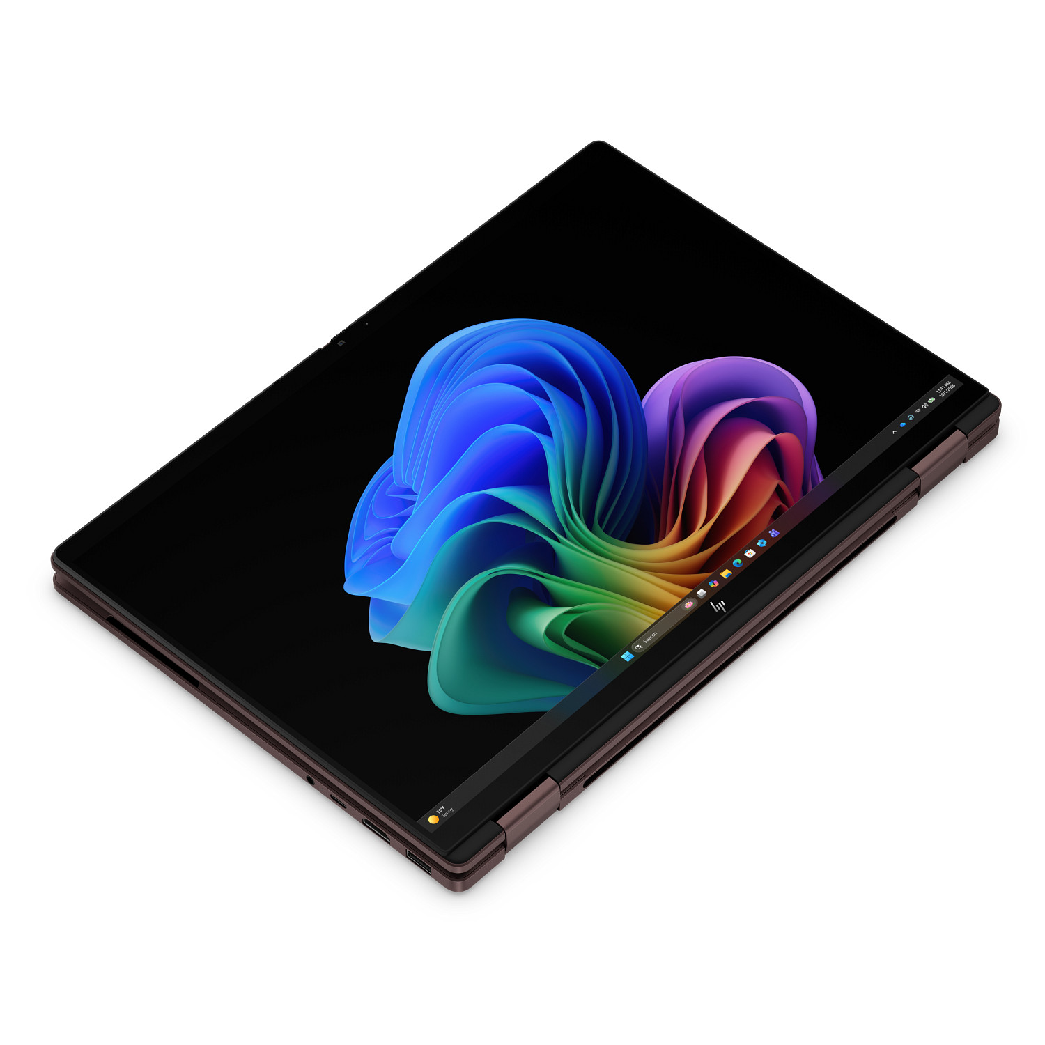 Un ordenador portátil de oro rosa cerrado con pantalla negra y un fondo de pantalla abstracto colorido.