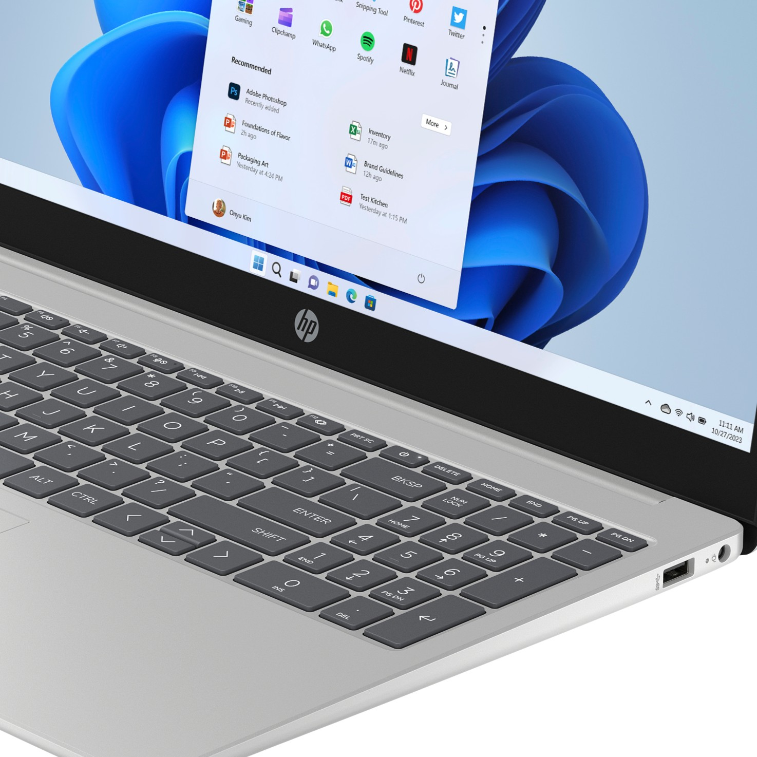 Portátil HP plateado mostrando el menú de inicio de Windows 11 en pantalla.