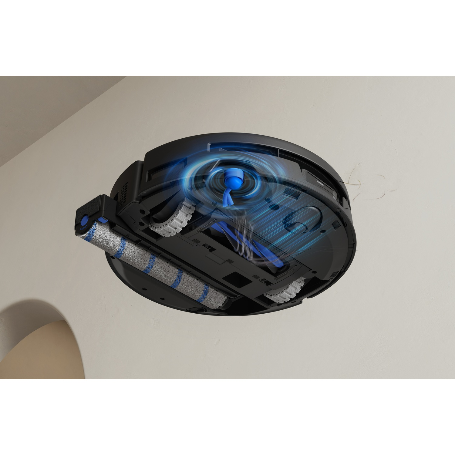 Parte inferiore di un robot aspirapolvere nero con effetti visivi di aspirazione contro una parete chiara.