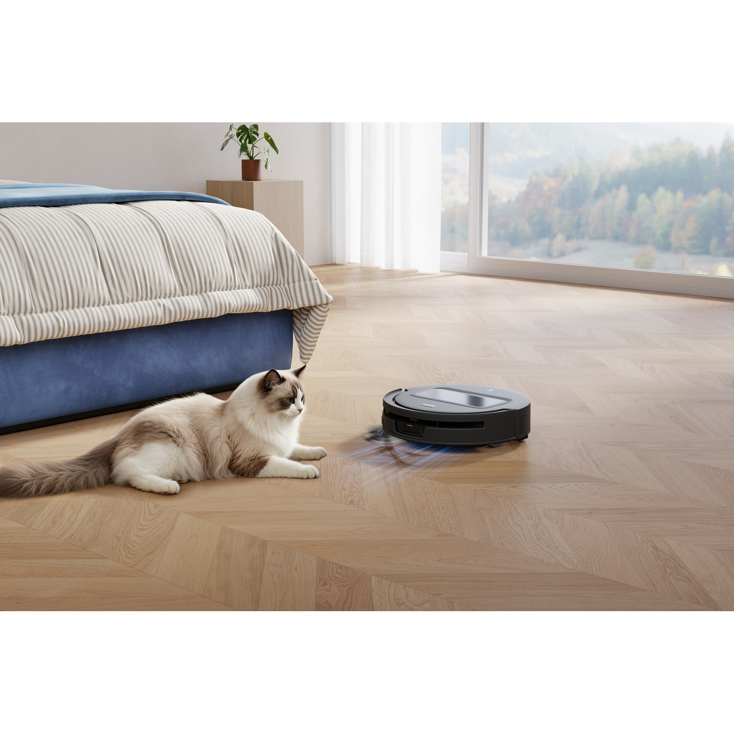 Un gatto bianco e marrone giace su un pavimento in legno vicino a un letto mentre un robot aspirapolvere pulisce.