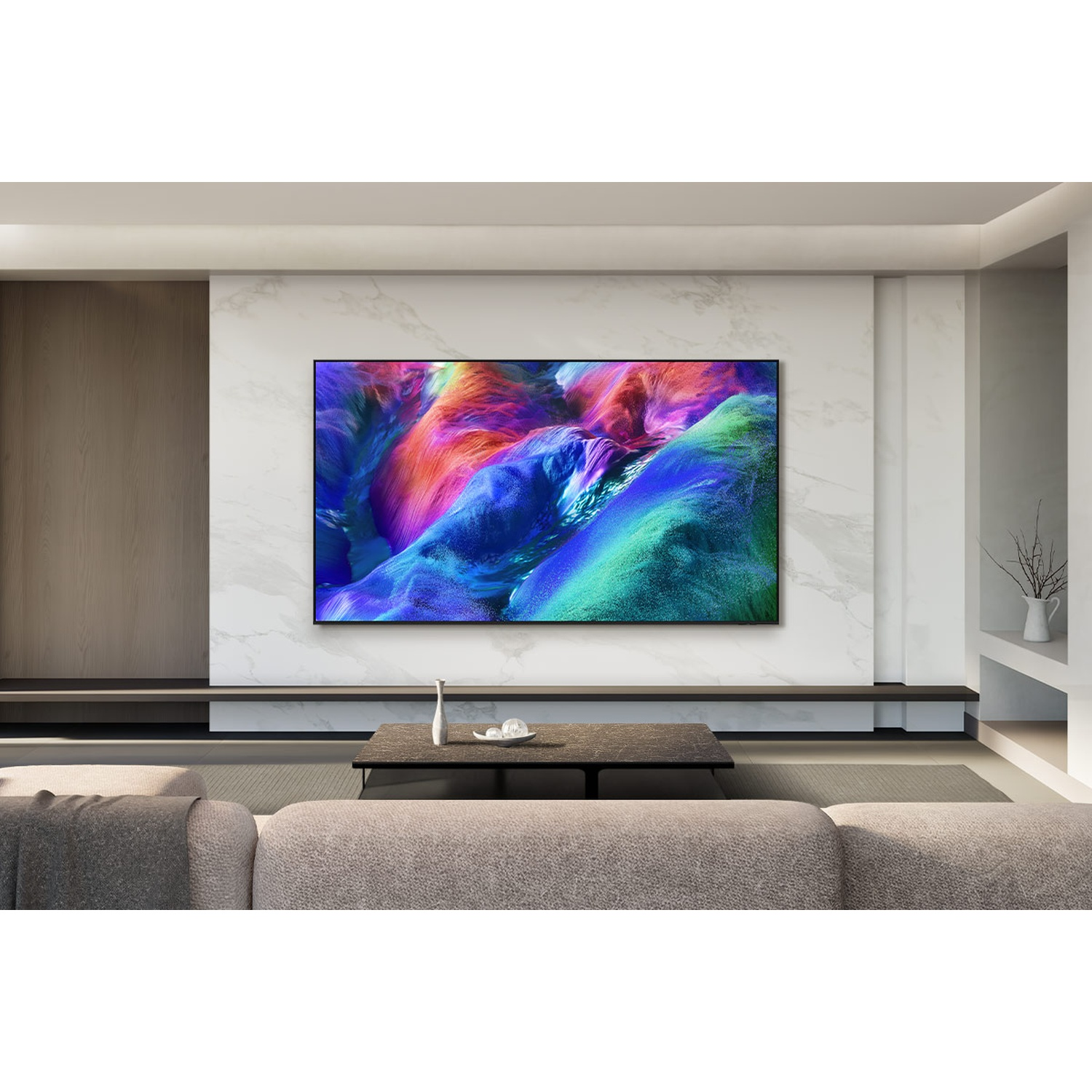 Moderne woonkamer met grote tv op marmeren wand, bank en lage tafel.