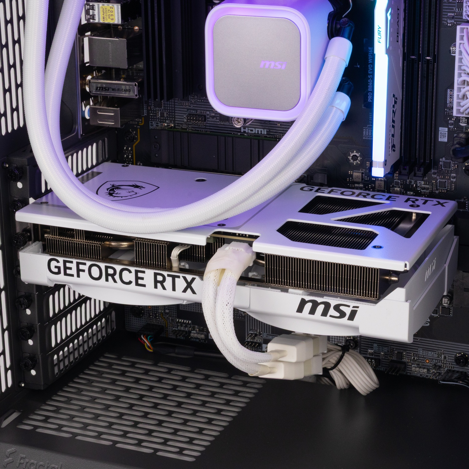 Inside of a gaming PC with a white MSI graphics card, liquid cooler, and glowing RAM sticks on a black motherboard.