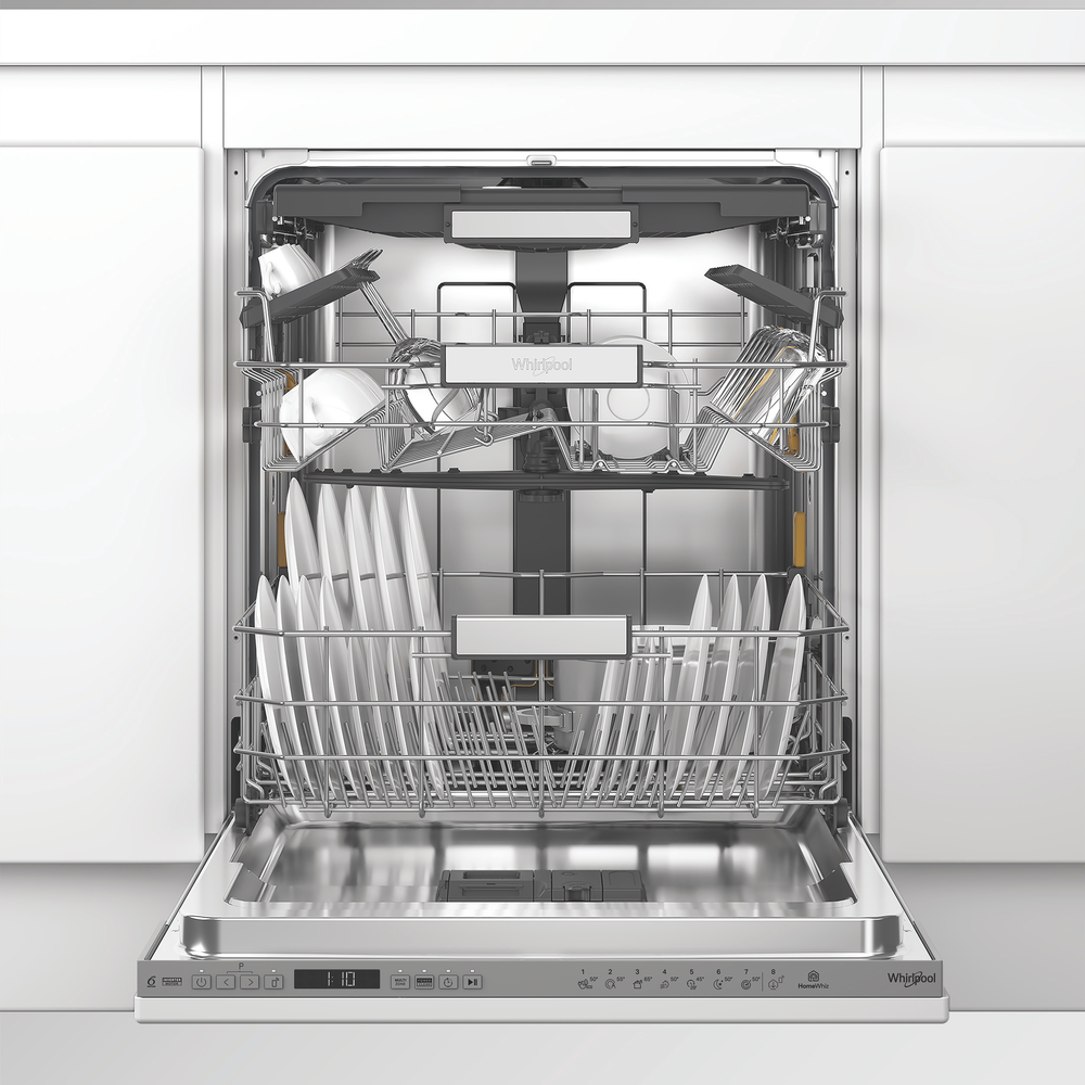 Nyitott Whirlpool mosogatógép két teli kosár edénnyel és tányérral egy fehér konyhában.
