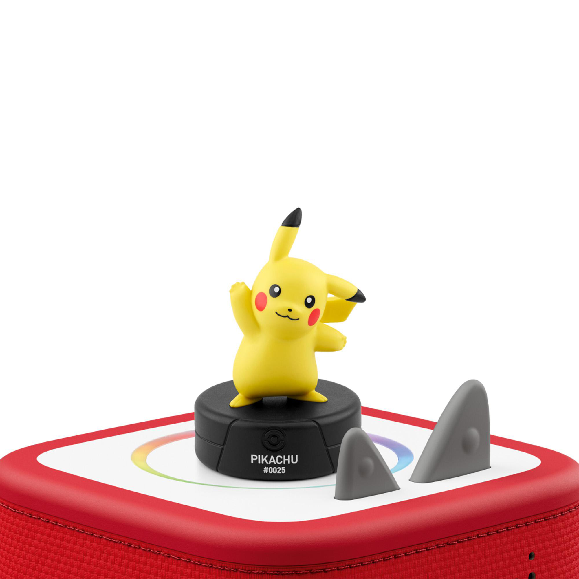 Eine gelbe Pikachu-Figur steht auf einem schwarzen Sockel auf einem rot-weißen Gerät mit kleinen grauen Ohren.
