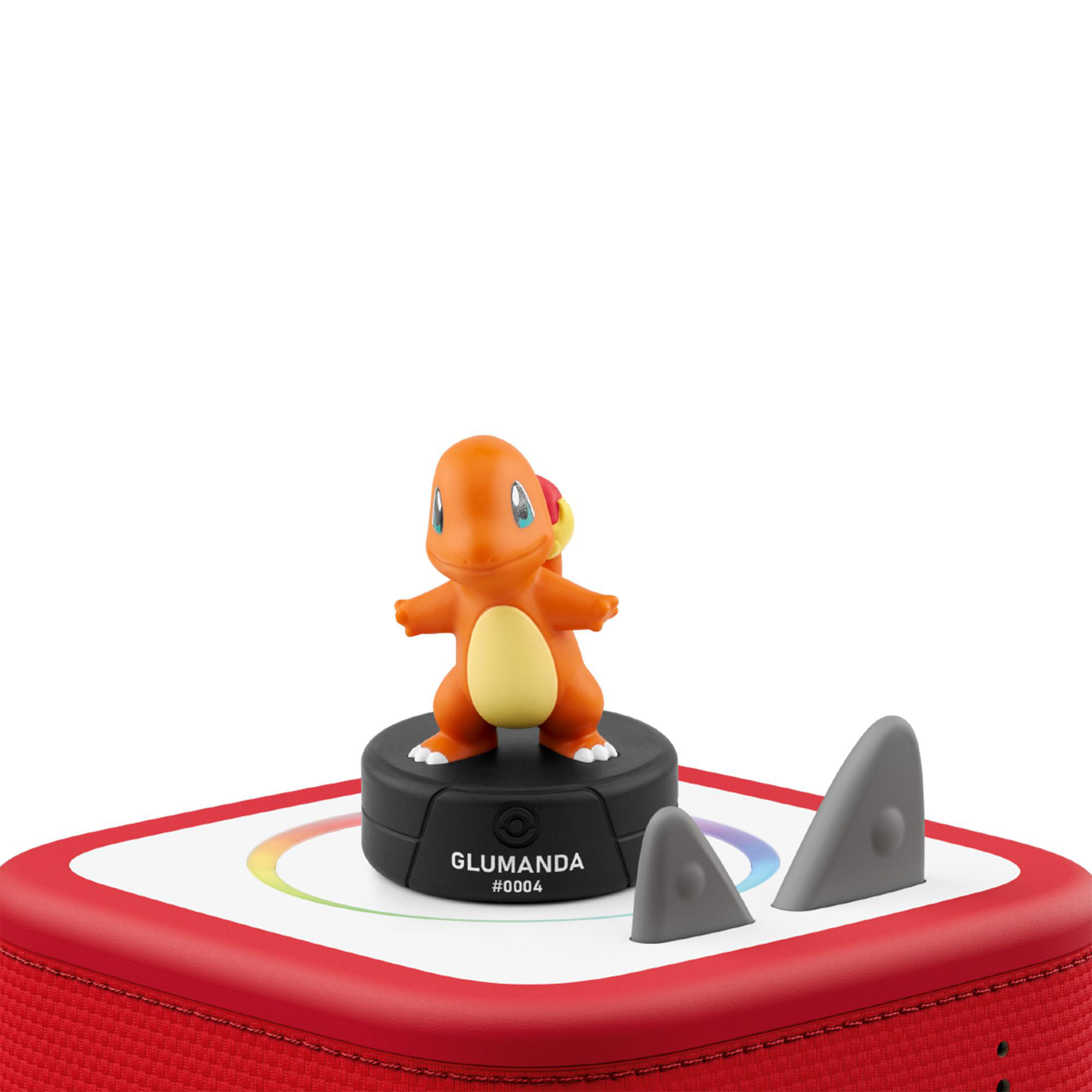Eine orangefarbene Glumanda-Figur steht auf einem schwarzen Sockel mit Aufschrift GLUMANDA.