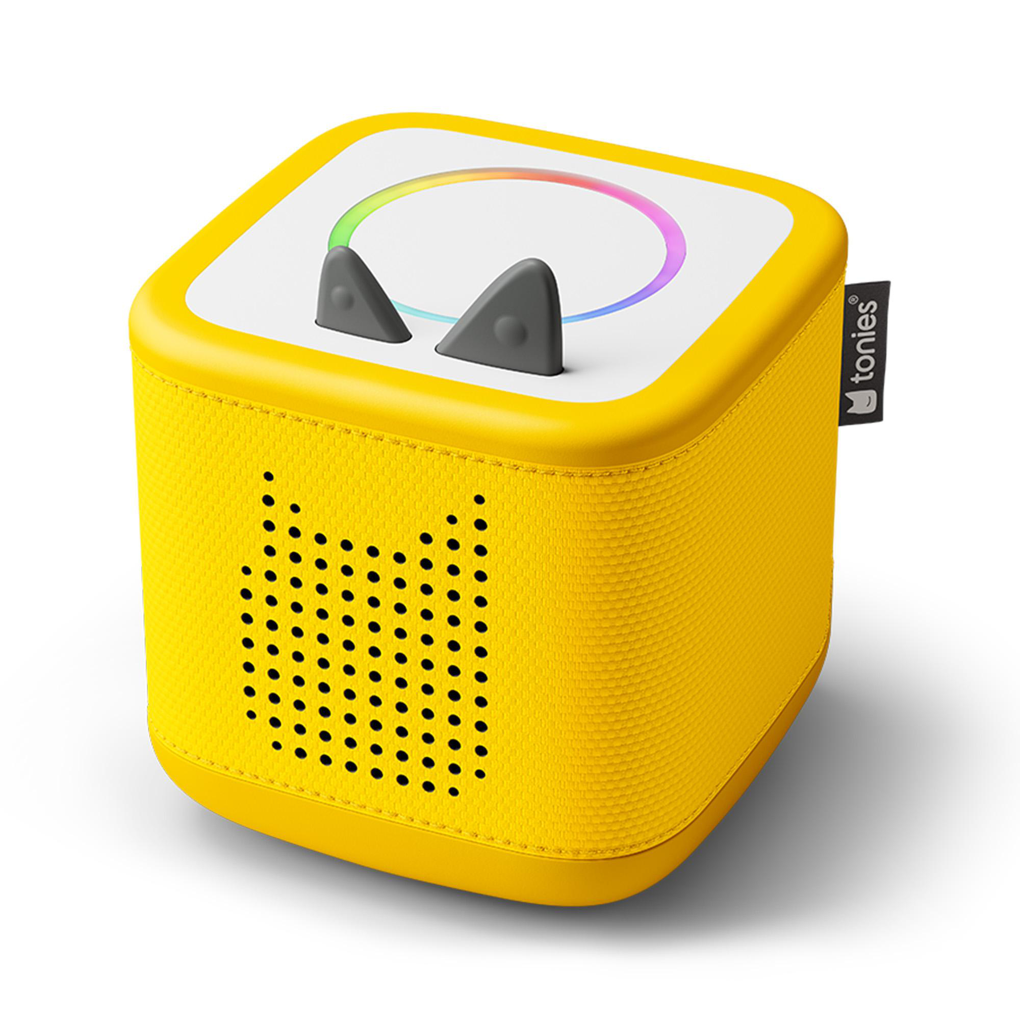 Gelber Toniebox-Audioplayer mit weißer Oberseite, farbigem LED-Ring und grauen Ohren auf weißem Hintergrund.