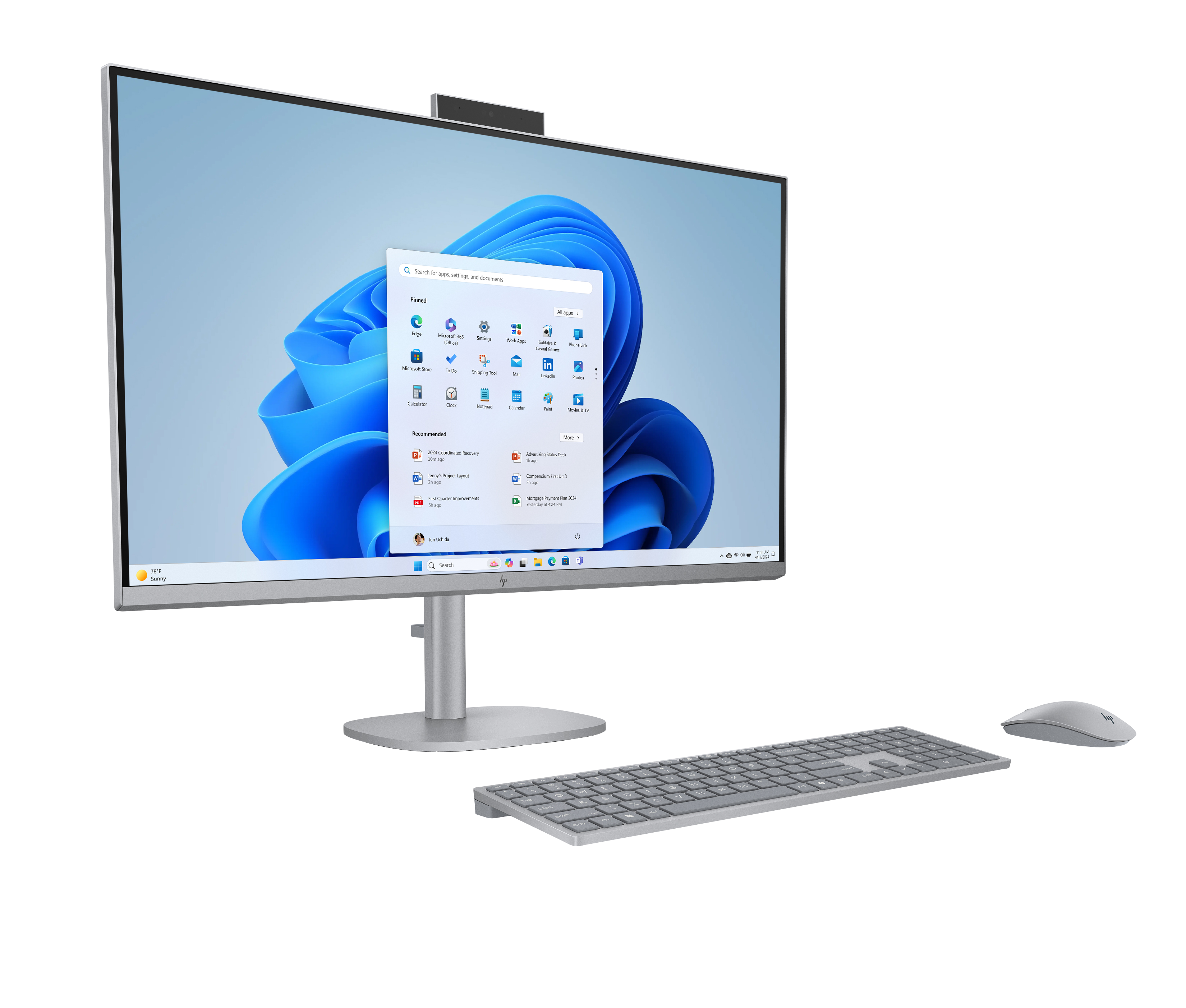 Ein silberner HP All-in-One-PC mit Tastatur und Maus auf schwarzem Hintergrund zeigt den Windows 11-Startbildschirm.
