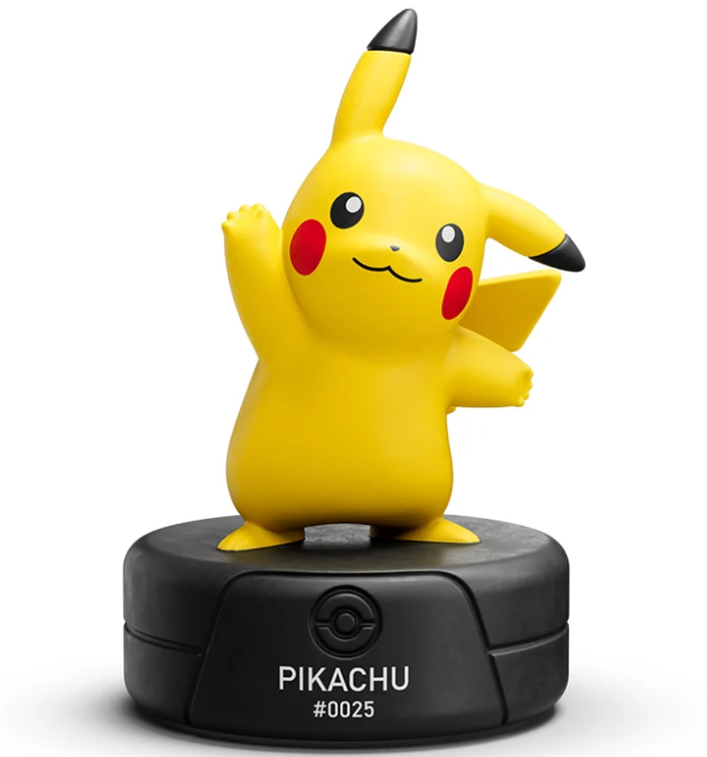 Gelbe Pikachu-Figur winkt stehend auf einem runden, schwarzen Sockel mit der Aufschrift PIKACHU #0025.