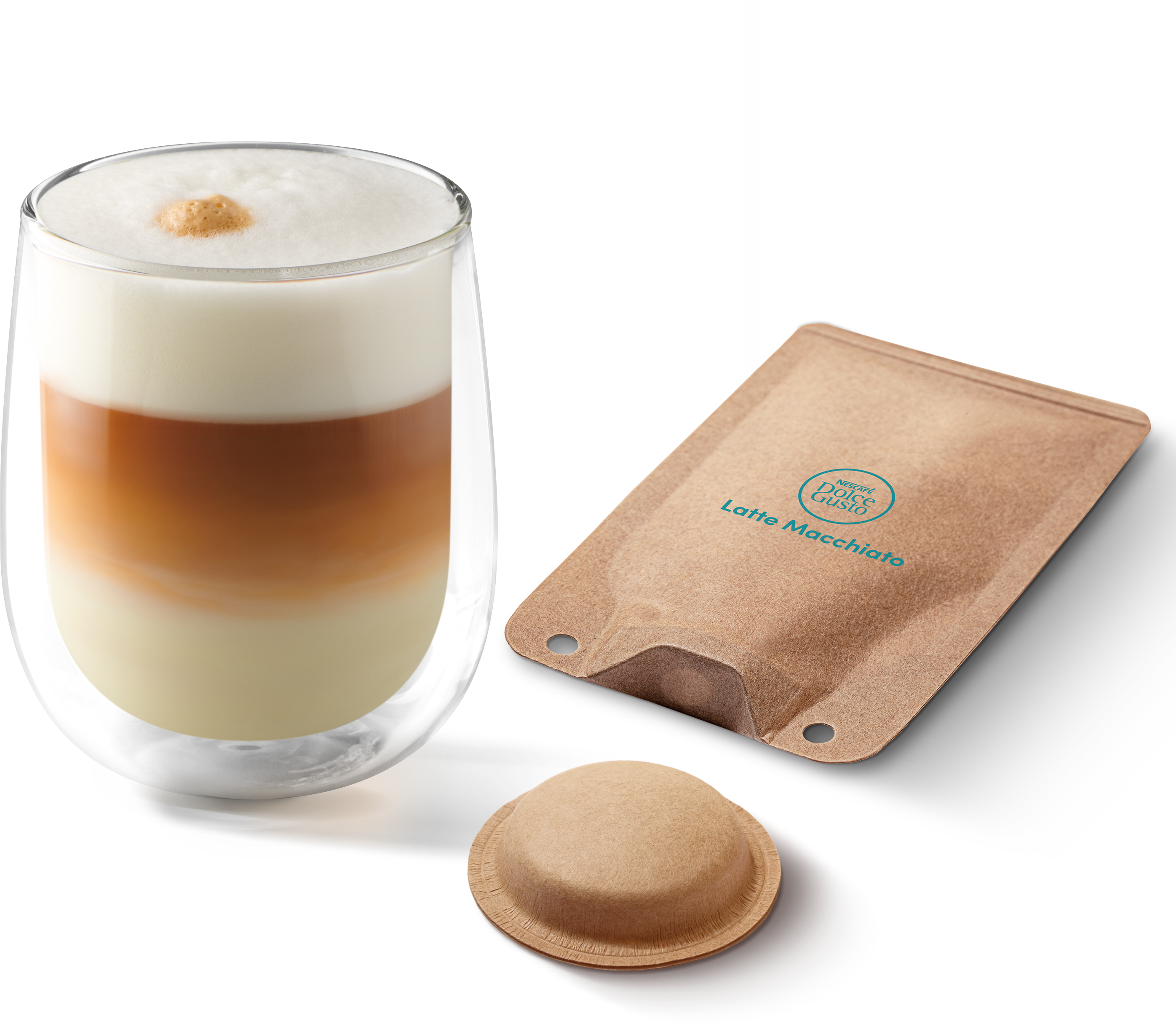 Ein geschichteter Latte Macchiato im Glas neben Kaffeepad und Verpackung vor schwarzem Hintergrund.
