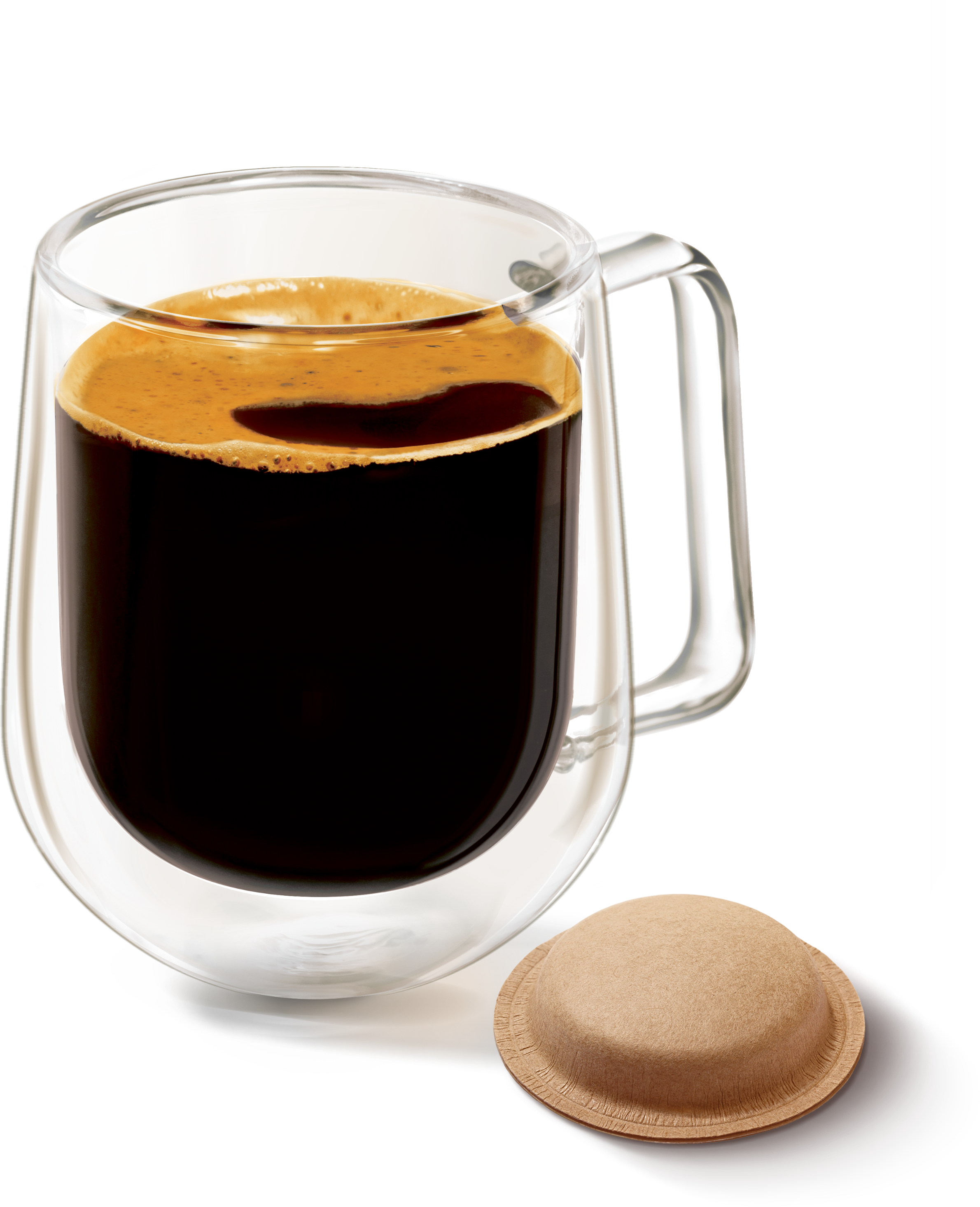 Eine Glastasse mit schwarzem Kaffee und Crema steht neben einem Kaffeepad auf schwarzem Hintergrund.